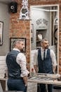 Man in Blue Vest Standing Beside Man in Gray Long Sleeve Shirt