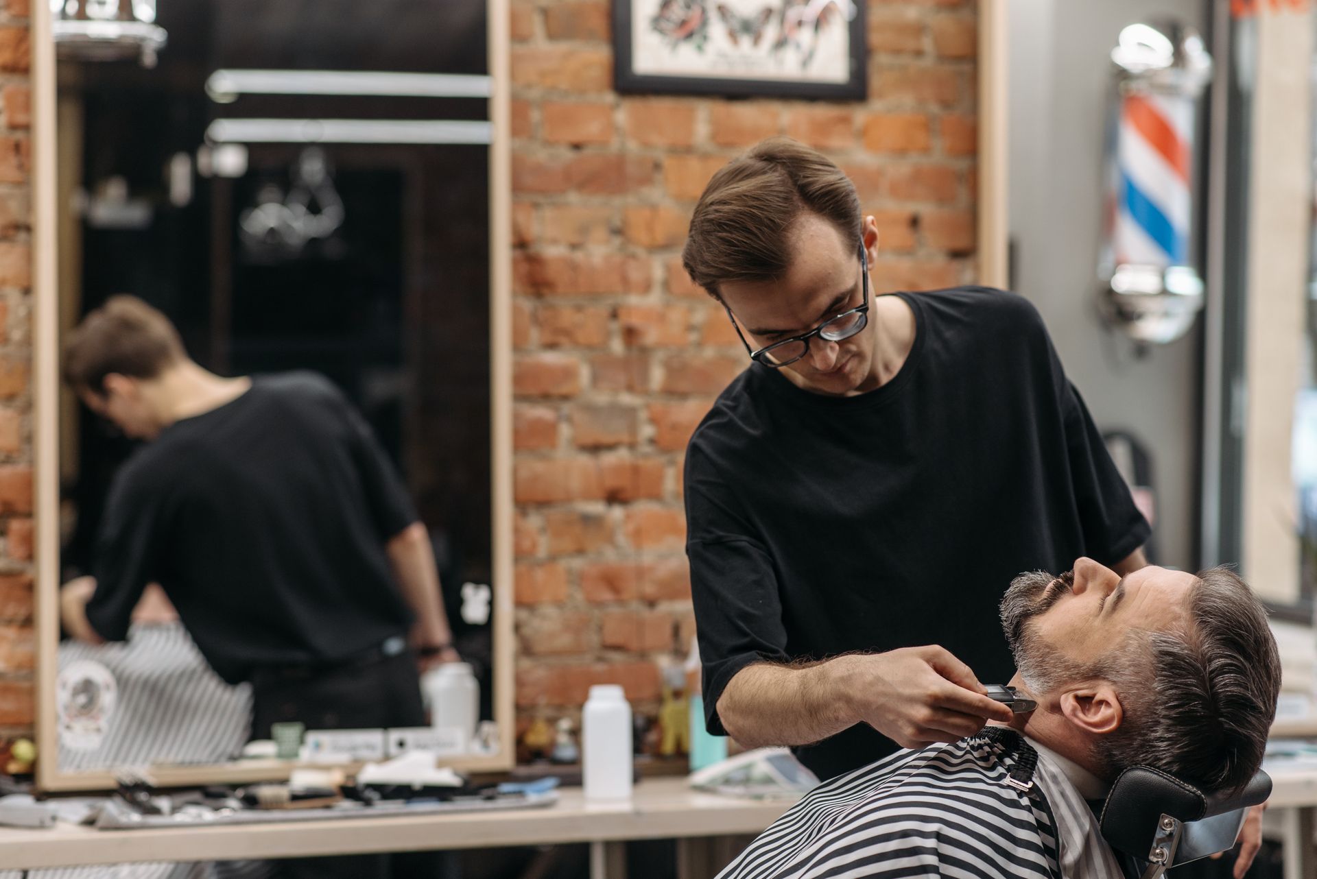 Photo of a Barber Shaving a Man's Beard