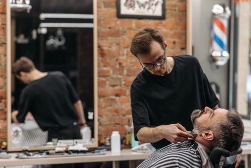 Free Close-up of a barber giving a beard trim at a stylish barbershop. Stock Photo
