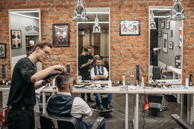 A Barber Cutting A Client's Hair
