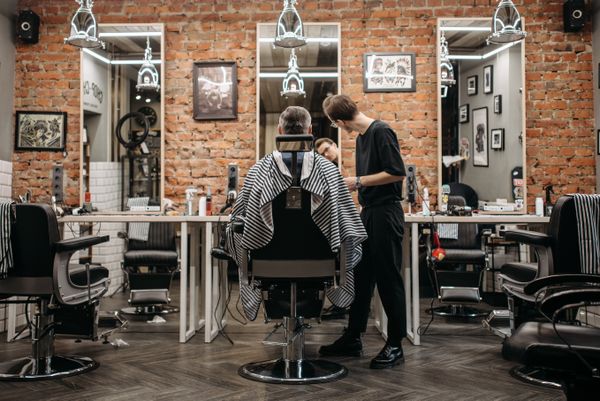 Barber working in a brick-walled room