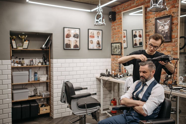 A Barber Using Blow Dry To His Customer