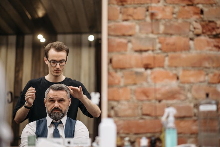 A Barber Doing Hairstyle To His Customer