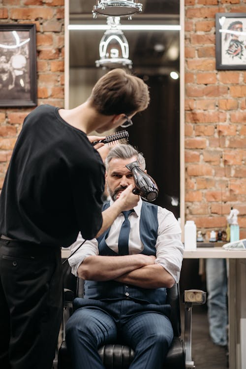 A Man Getting His Hair Styled in a Barbershop