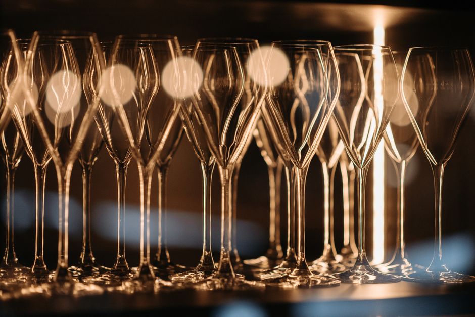 A stylish arrangement of empty wineglasses under soft lighting, ideal for restaurant themes.