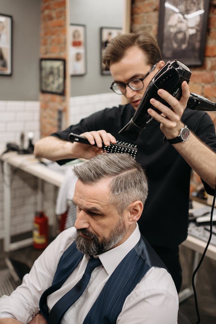 A Barber Using A Blow Dry On A Customer