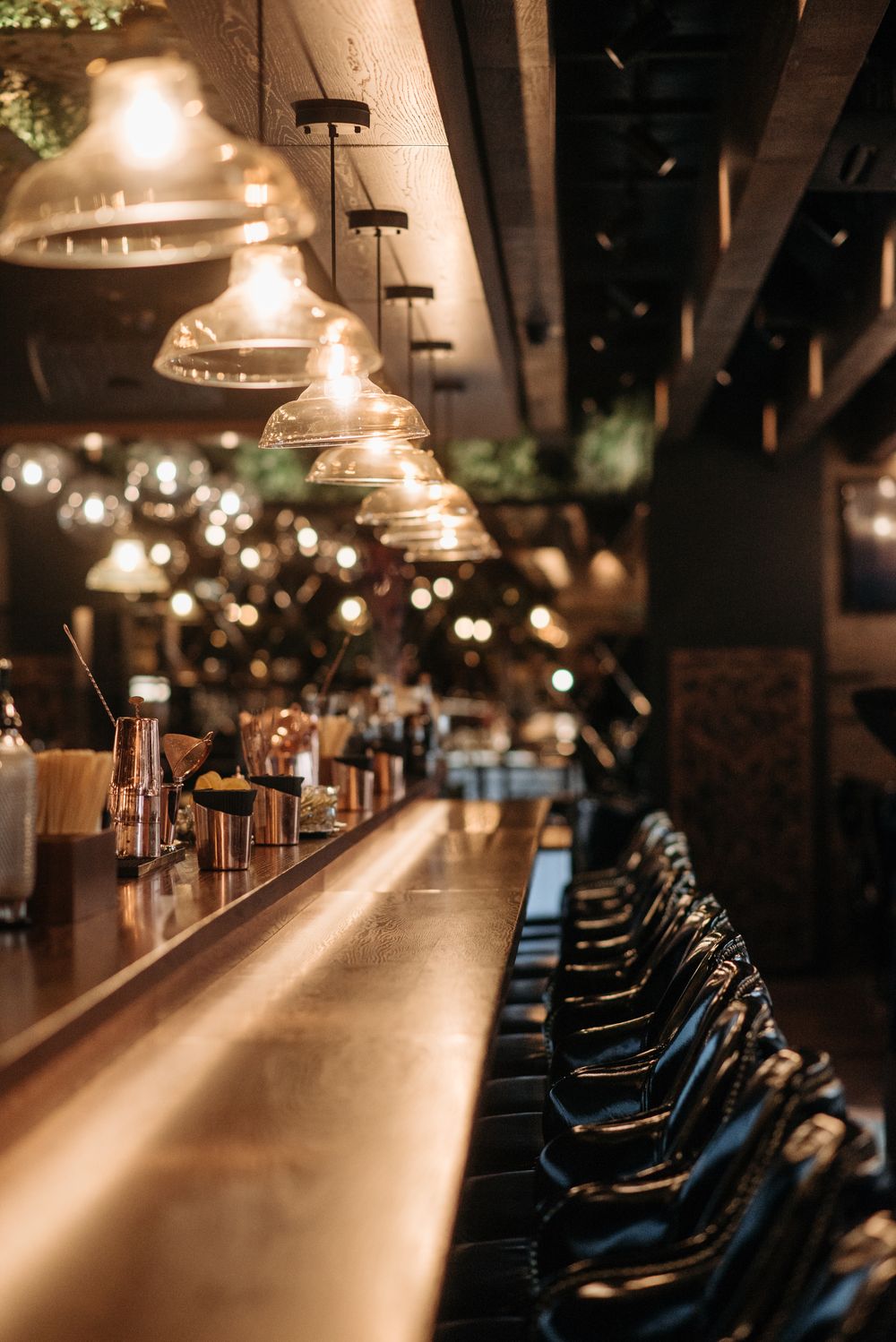 Warmly lit bar counter with empty stools