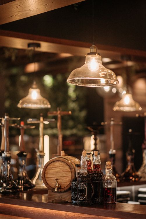 Bottles of Alcoholic Drinks near a Barrel · Free Stock Photo
