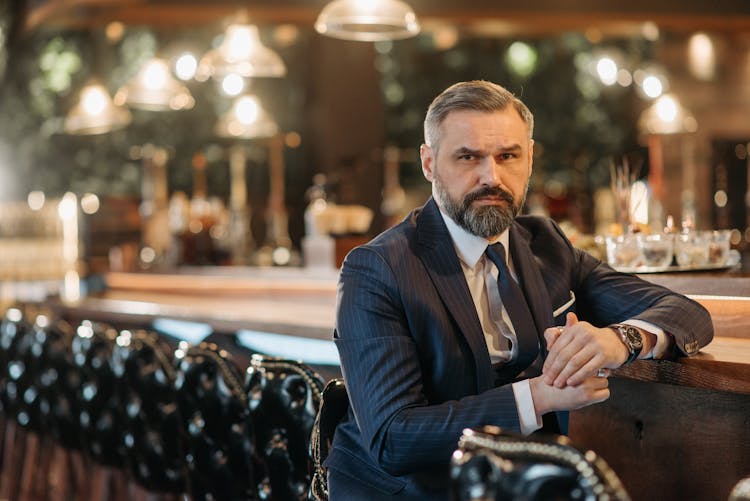 Stylish Man In Blue Suit Sitting At The Bar Counter