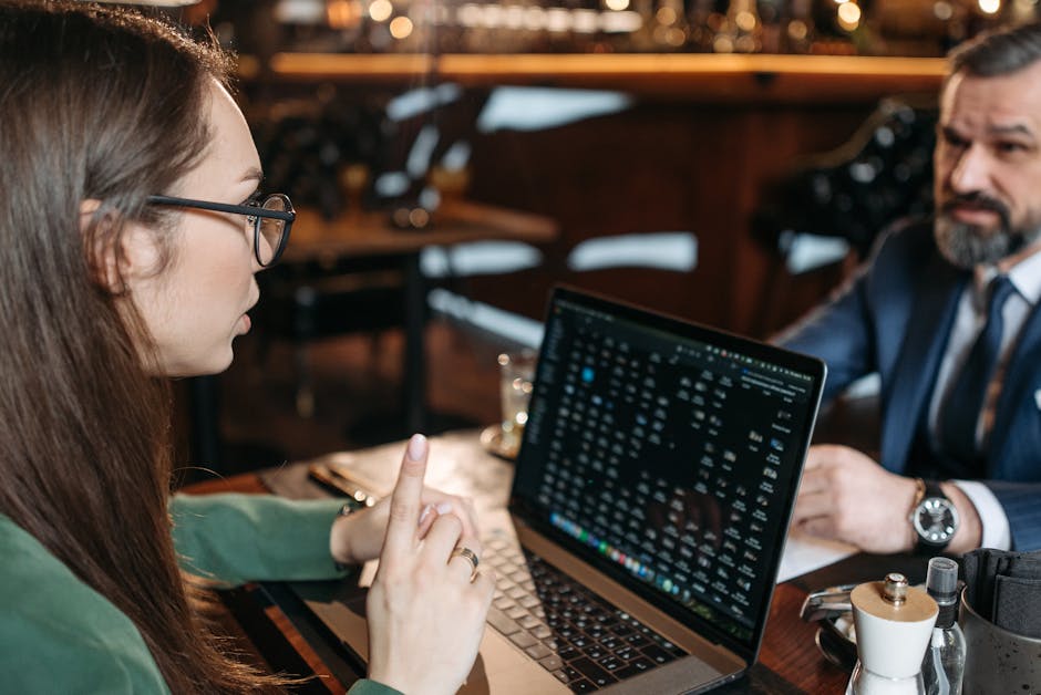 1Password, Bitwarden, Dashlane: 7 Things to Know Professional discussion during a business meeting in a restaurant with laptop visible.