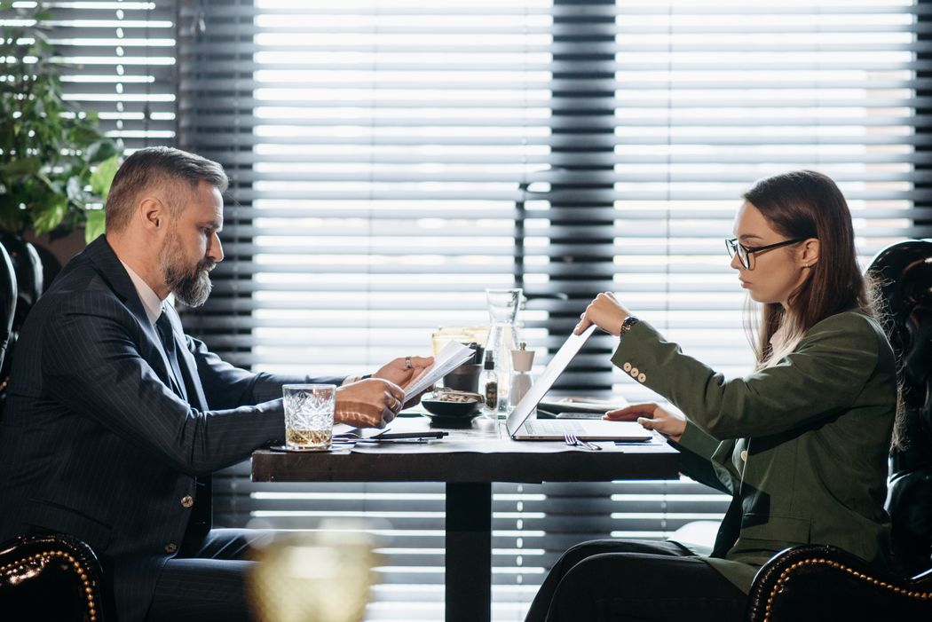 Professionals discussing application documents at a laptop