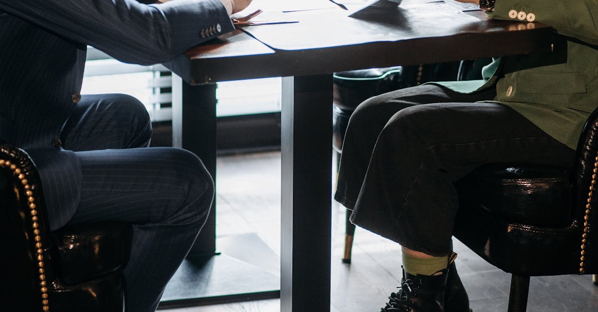 Two business professionals engaged in a serious discussion at a modern office table.