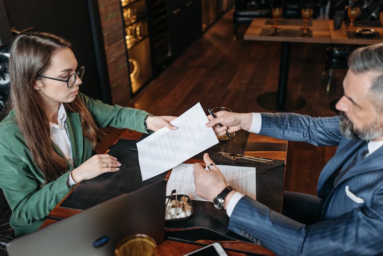 Woman Giving Paper To Man 