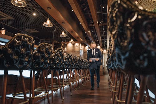 A Man Walking Inside a Restaurant Holding Some Documents