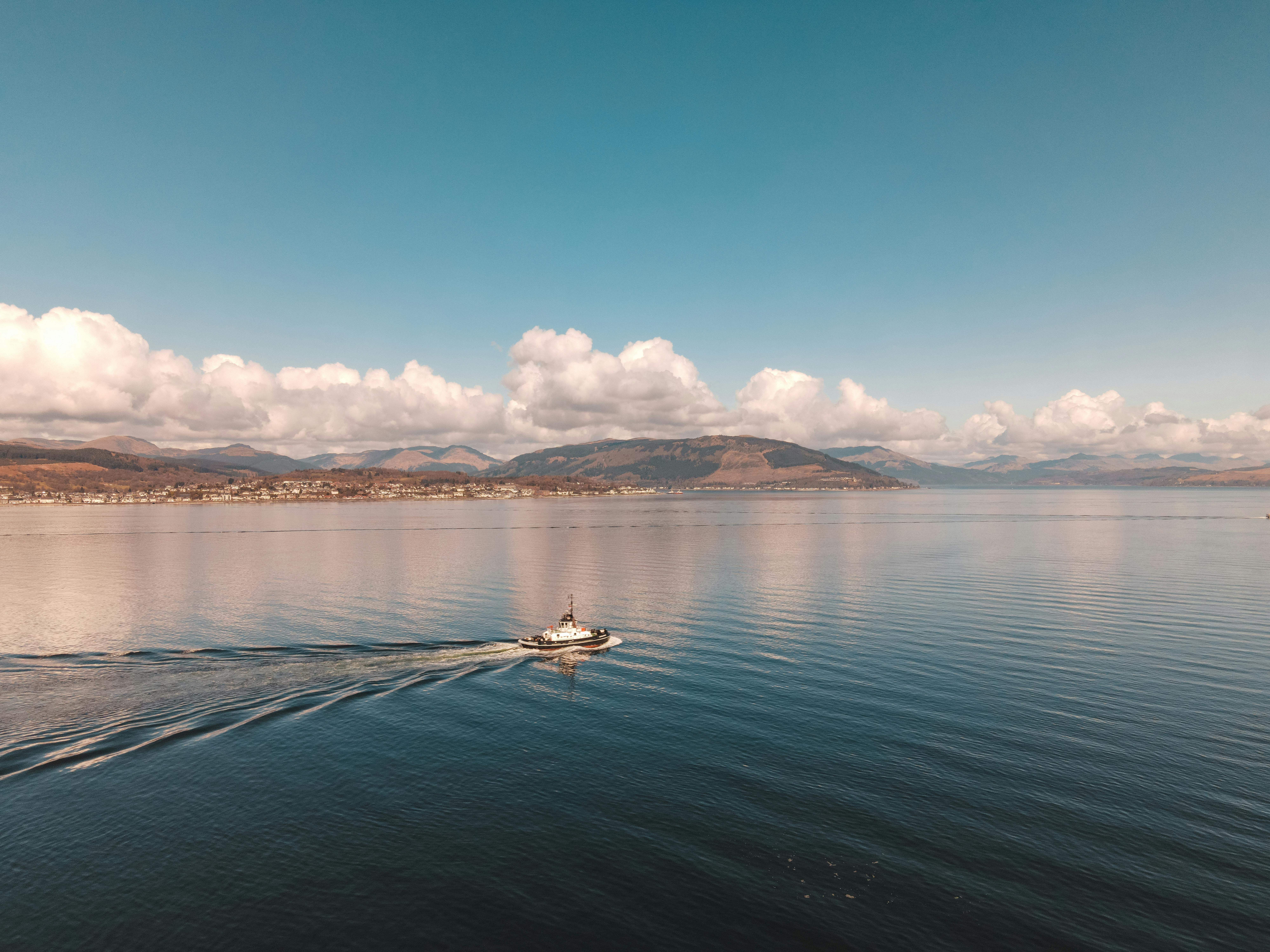 A peaceful scene of a solitary boat sailing on Loch Firth in Greenock, Scotland.