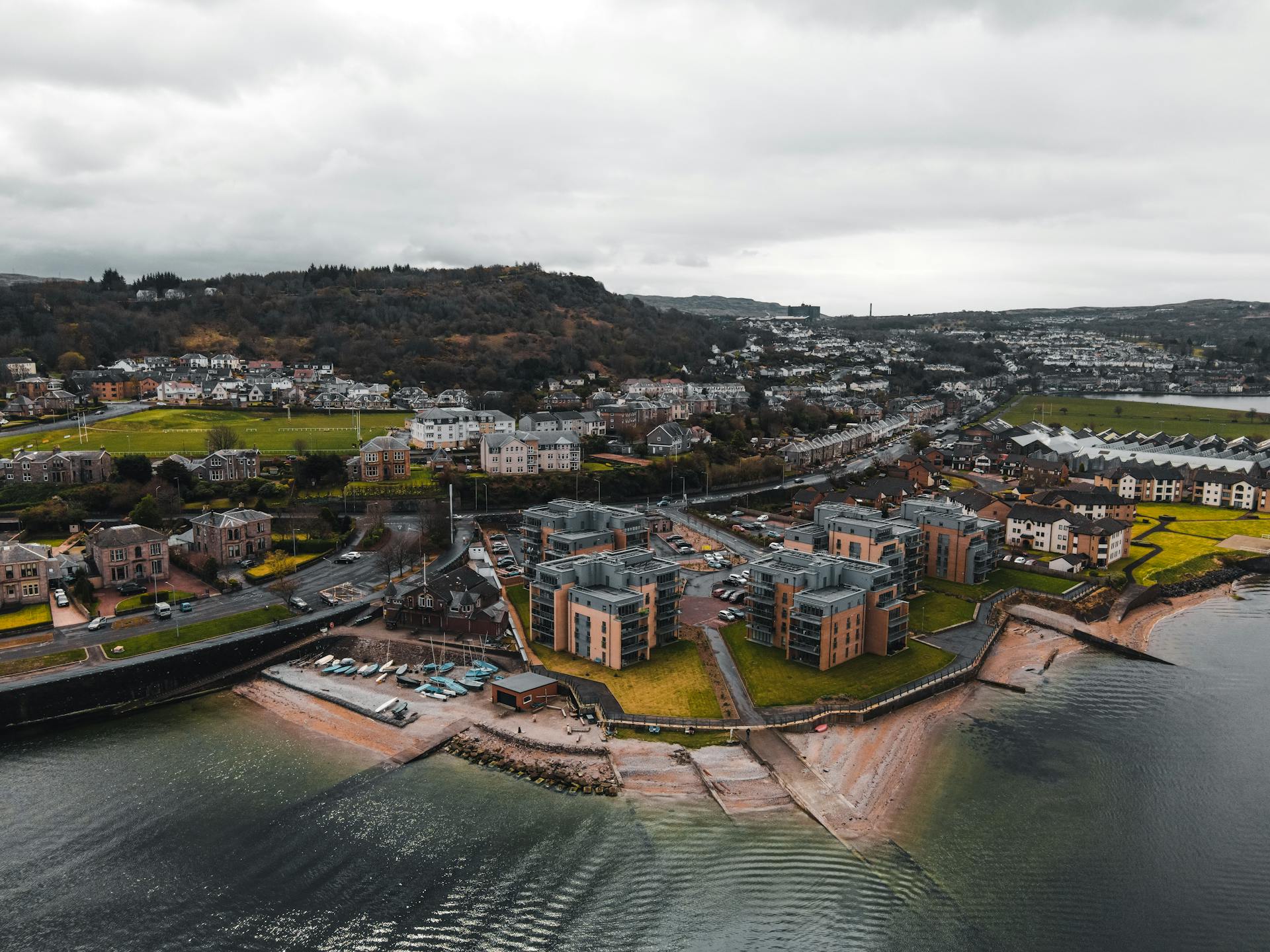 Aerial view of a coastal town in Scotland showing buildings and sea shore.