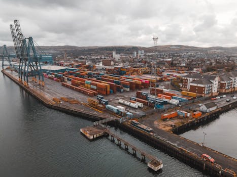Aerial view of Greenock Harbor showcasing shipping containers and infrastructure in Scotland.