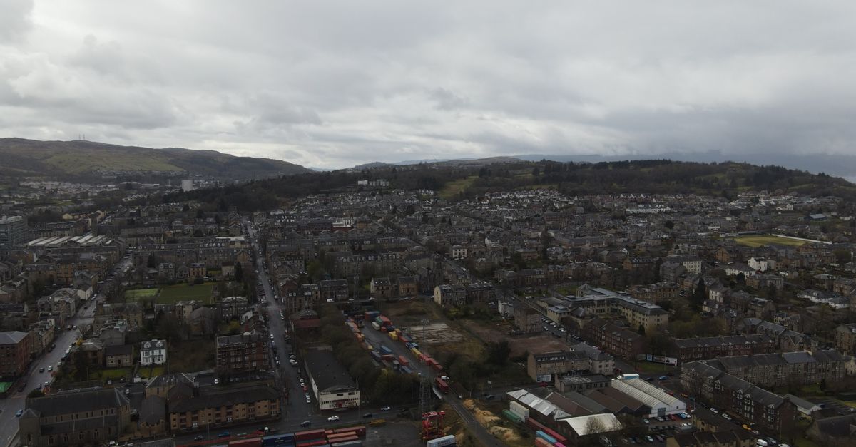 Aerial view of urban landscape and container terminal in Scotland, showcasing dense housing and logistics.