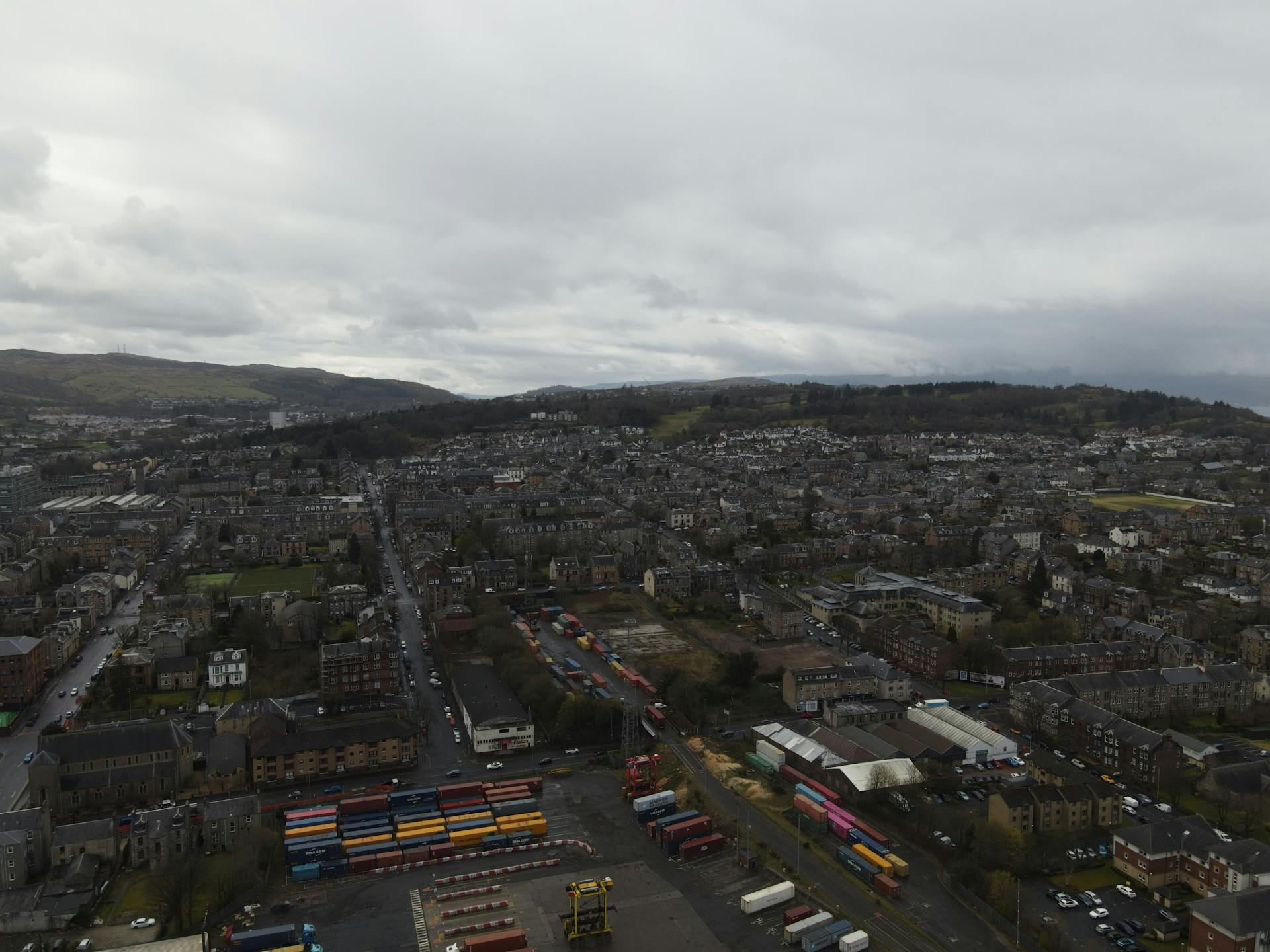 Aerial view of urban landscape and container terminal in Scotland, showcasing dense housing and logistics.