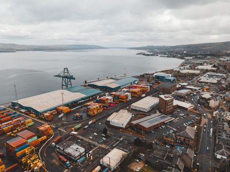 Drone shot of Greenock Harbor, Scotland, showcasing shipping infrastructure by the coast.