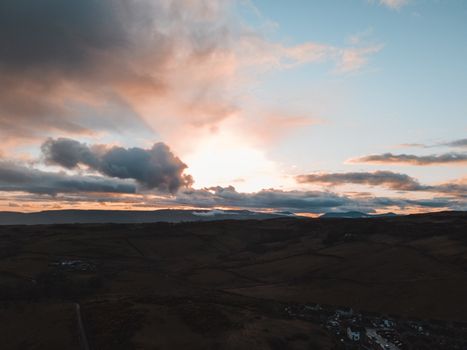 A stunning aerial landscape of the Scottish countryside during dusk with dramatic skies.