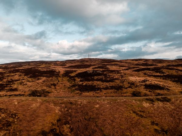 Rolling brown and green moorland hills in the Scottish Highlands under cloud