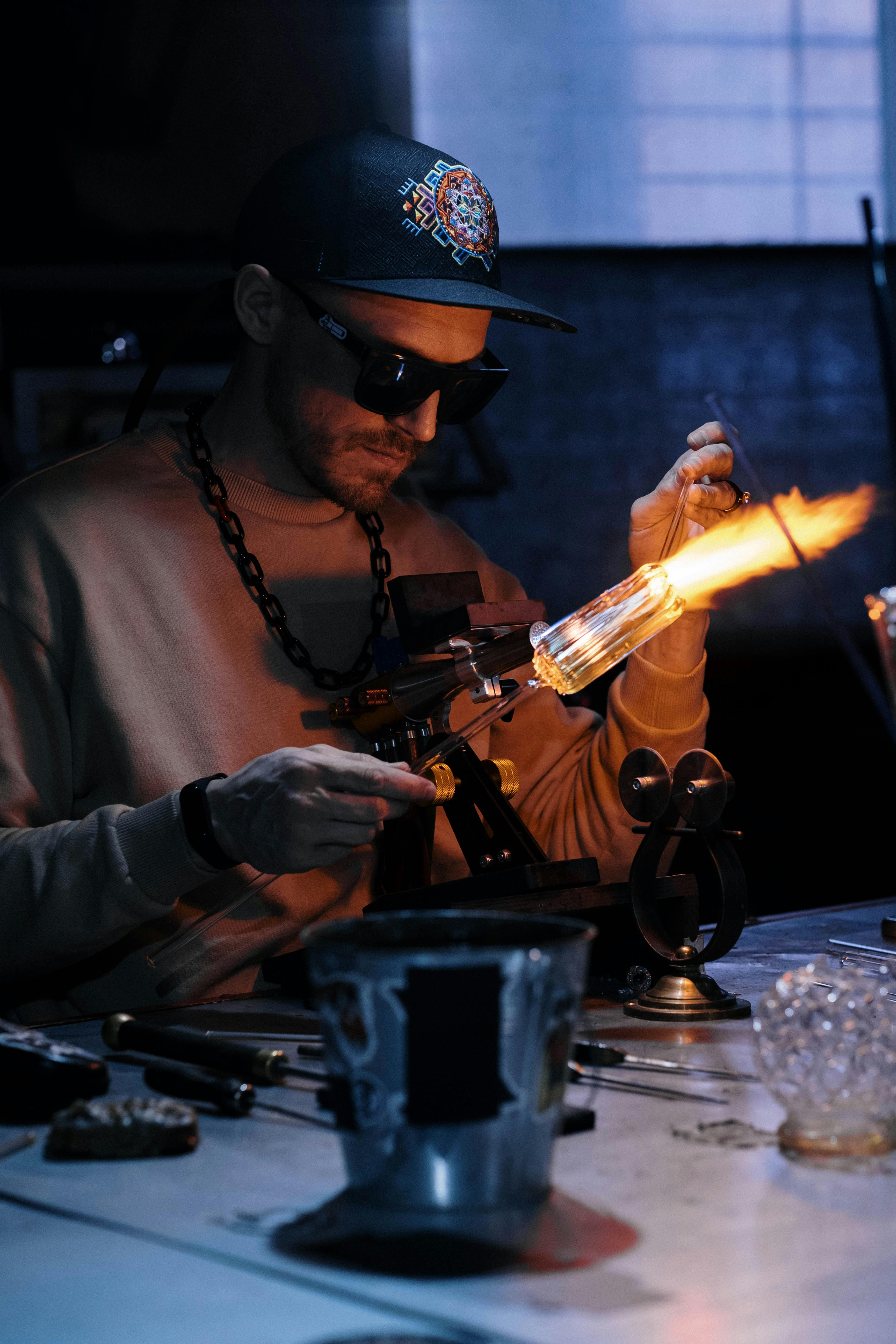 man using a burner for manufacturing glass items in a workshop