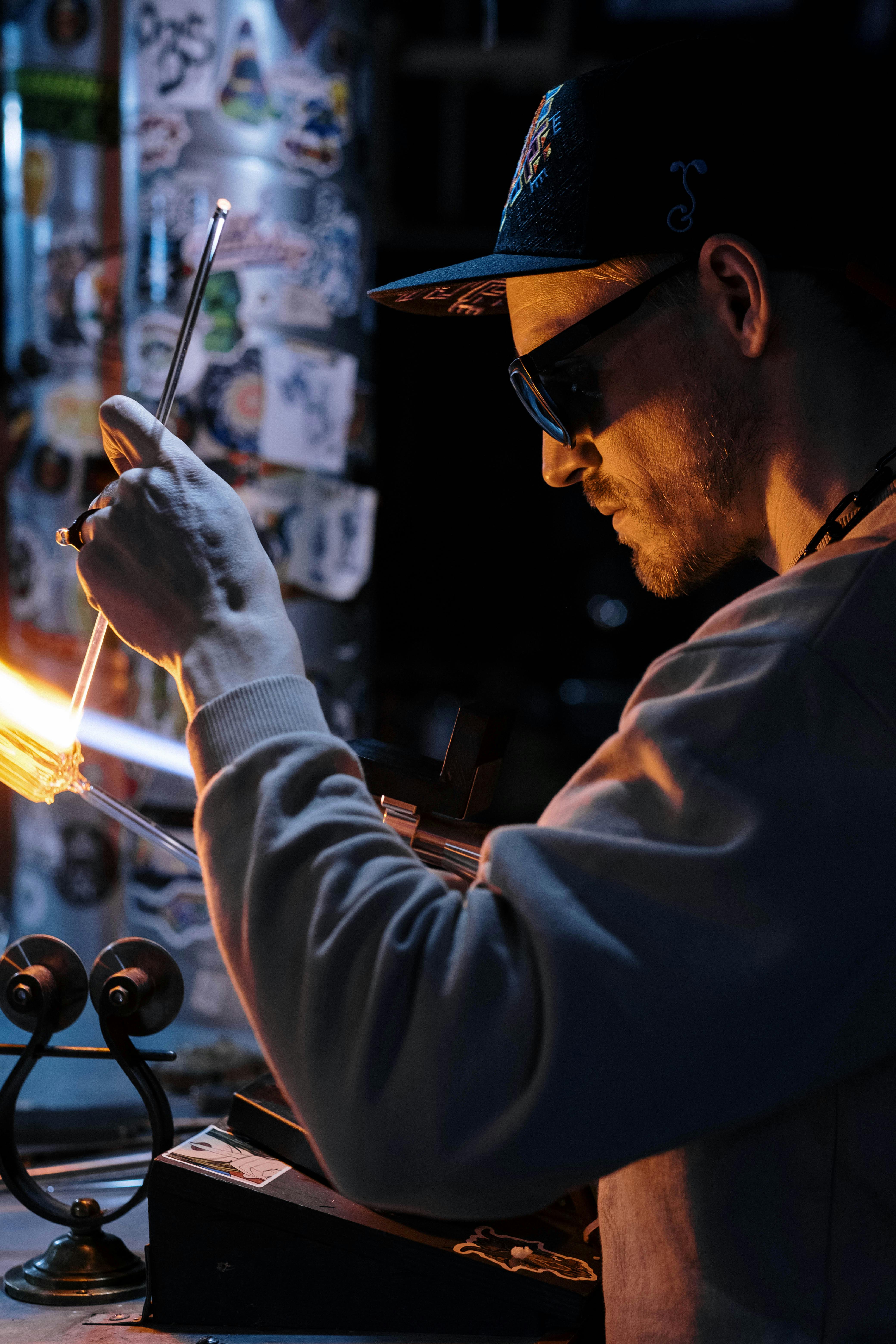 man using a burner for manufacturing glass items in a workshop