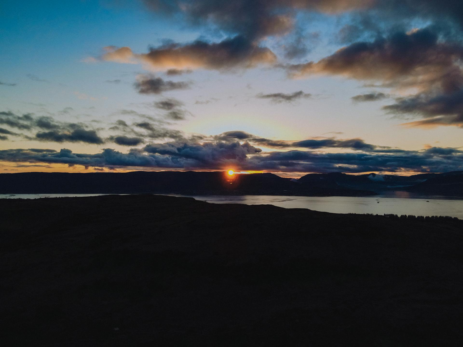 A breathtaking sunset over Scottish coast with vibrant skies and calm sea.
