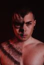 Topless Man With Red and Black Paint on Face