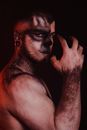 Topless Man With Red Paint on Face