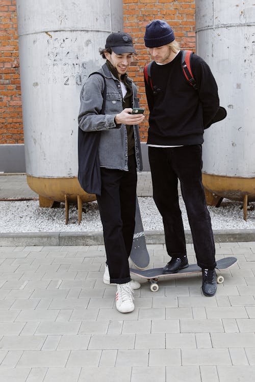 Men with Skateboards Using a Cellphone