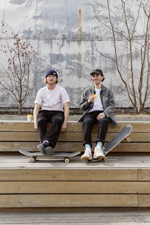 Two Men Sitting with Their Skateboards