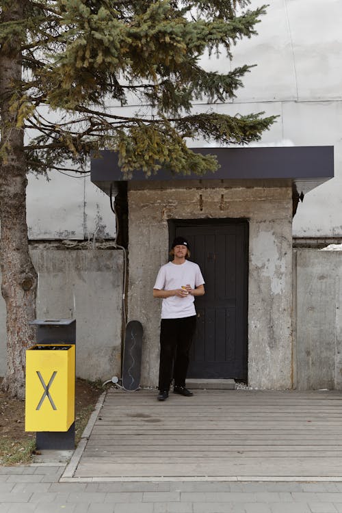 Man in White Shirt Standing on the Doorway