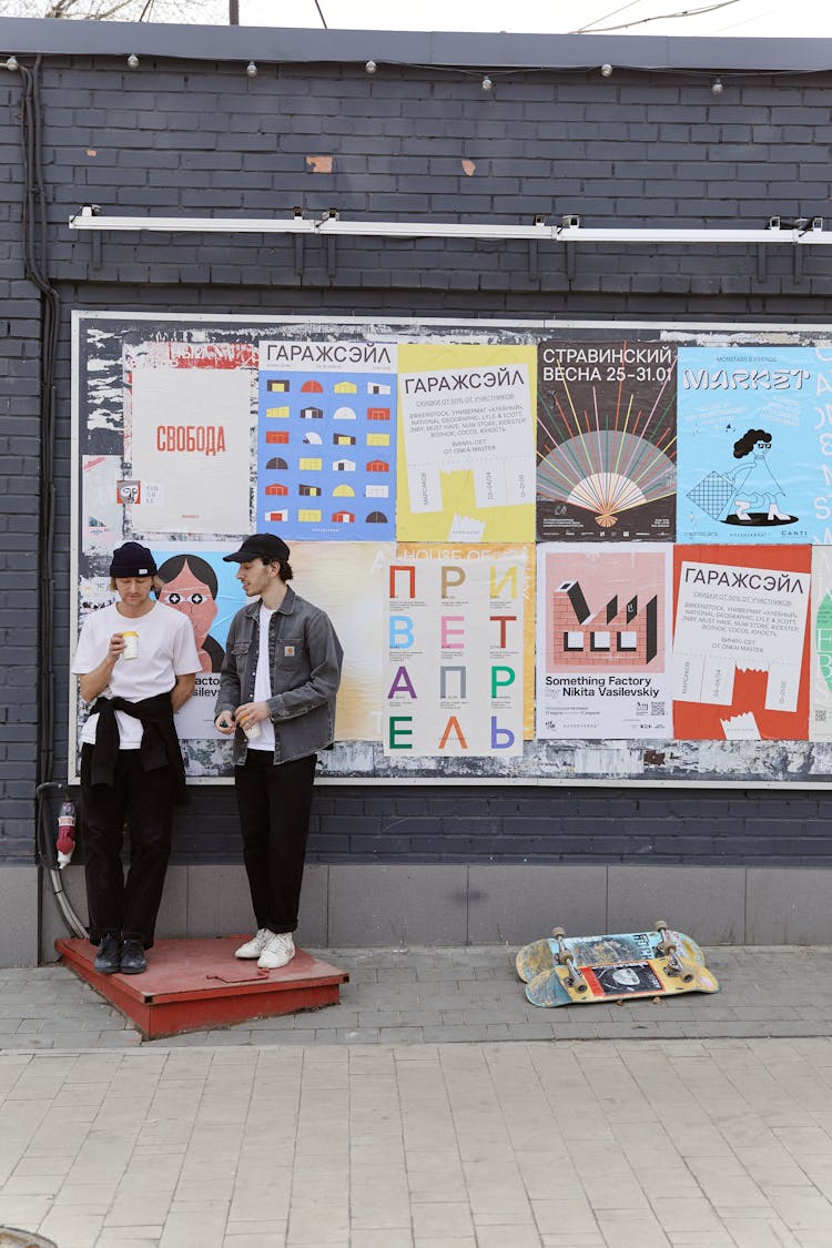 Men Standing In Front Of A Billboard