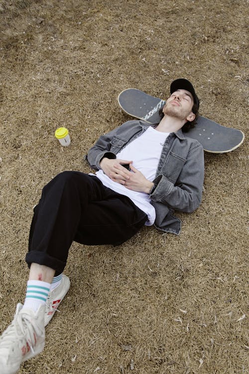 Free High-Angle Shot of a Man Resting on His Skateboard Stock Photo