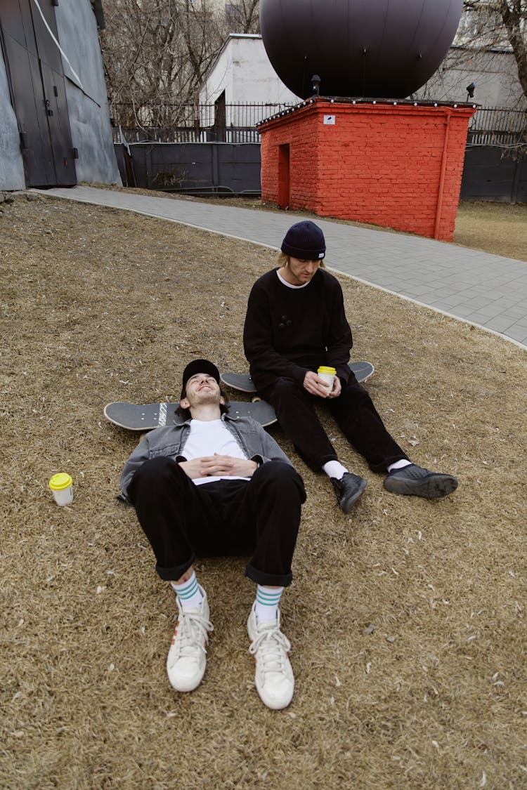 Men Relaxing On Grassy Area