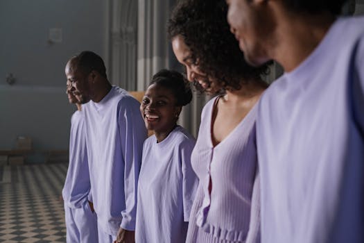 A joyful group of choir members wearing lavender attire, smiling indoors.