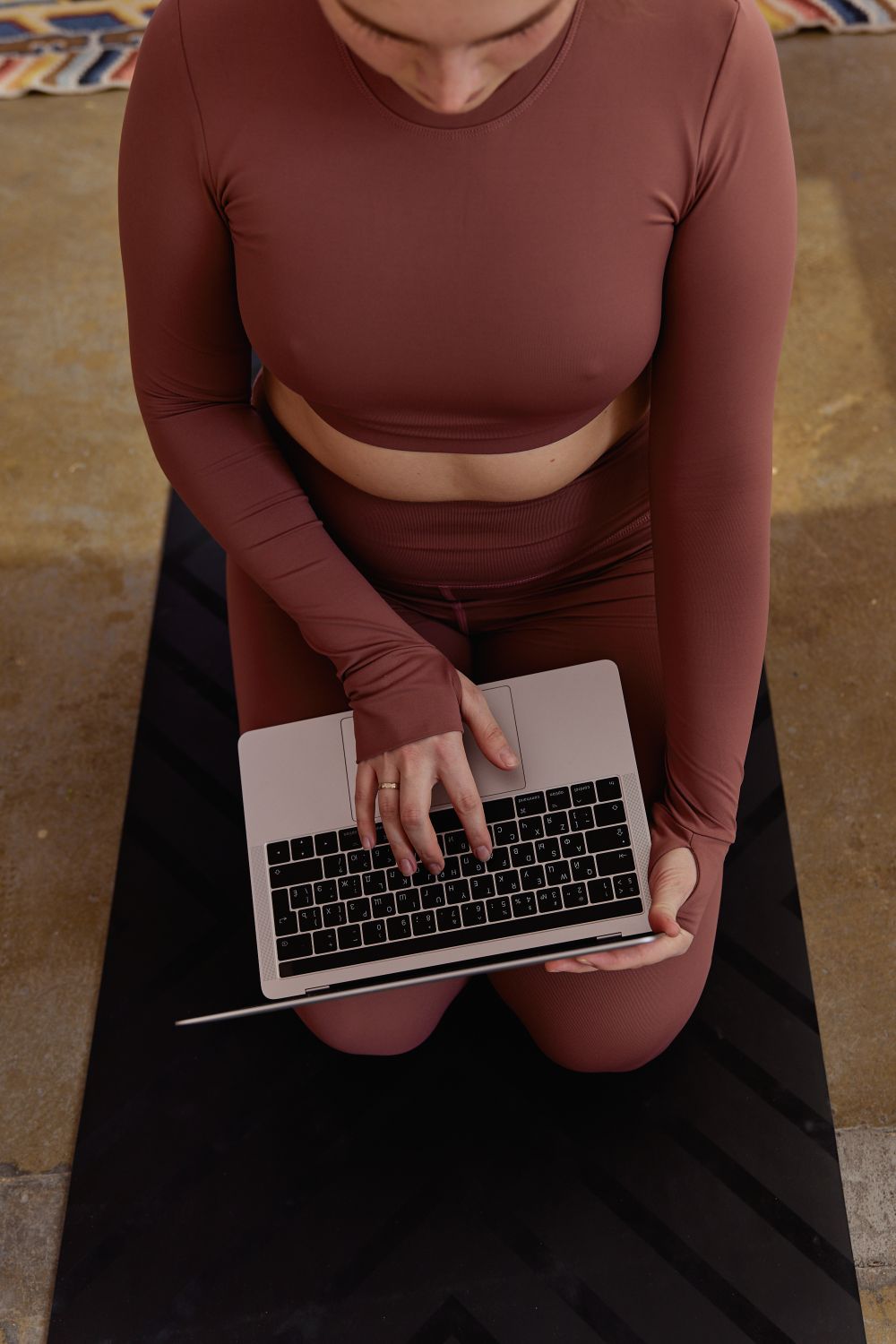 A Woman Using Her Laptop while on a Yoga Mat · Free Stock Photo