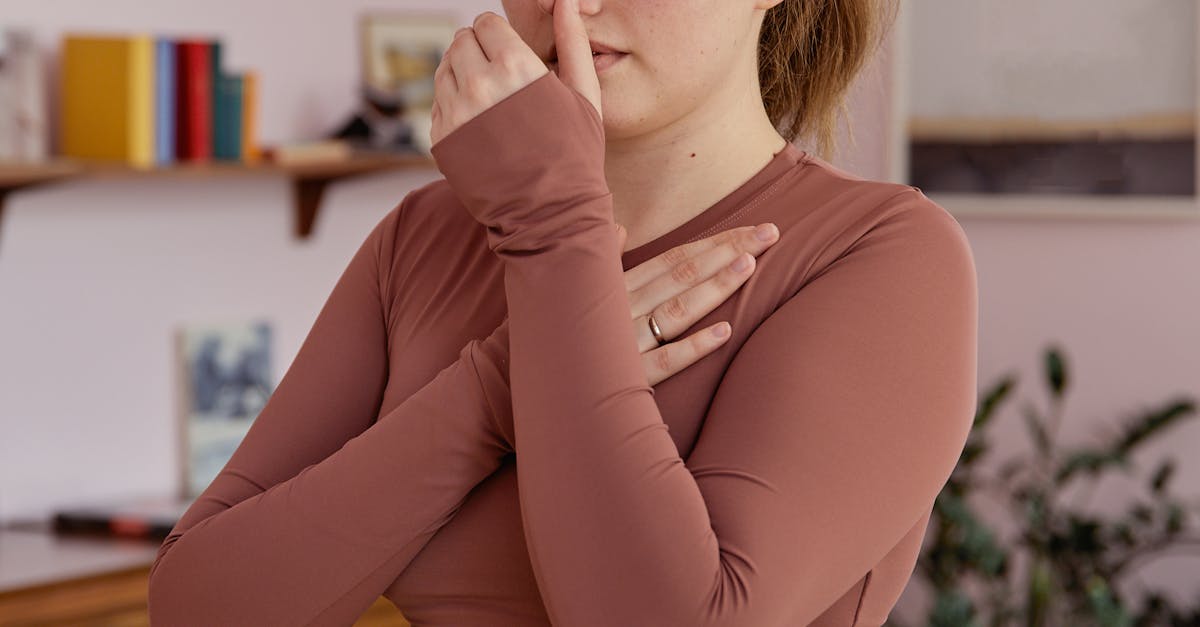 Plus-size woman in activewear performing breathing exercises indoors, promoting wellness and mindfulness.