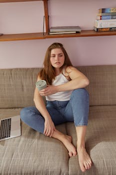 Woman at home sitting on a couch with a laptop, embracing the remote work lifestyle.