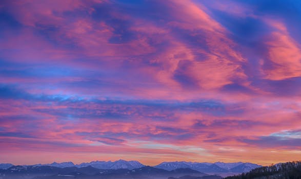 Stunning sunset over Schwambach mountains with vibrant pink and purple sky.