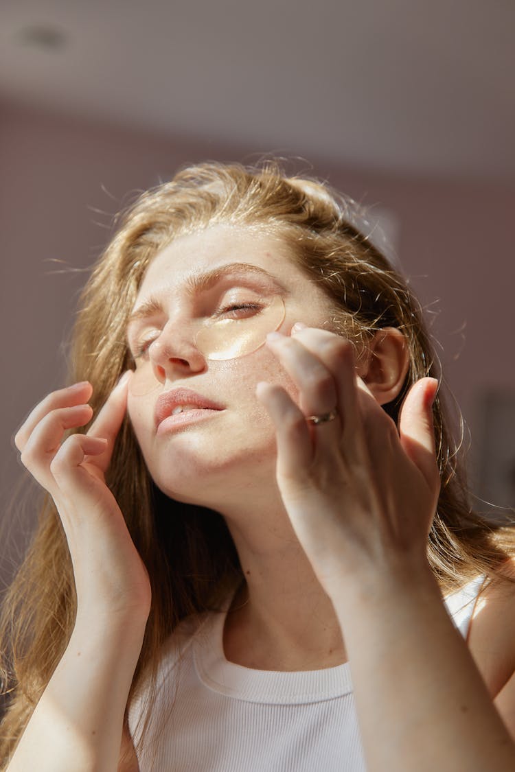 A Woman Applying Under Eye Patches