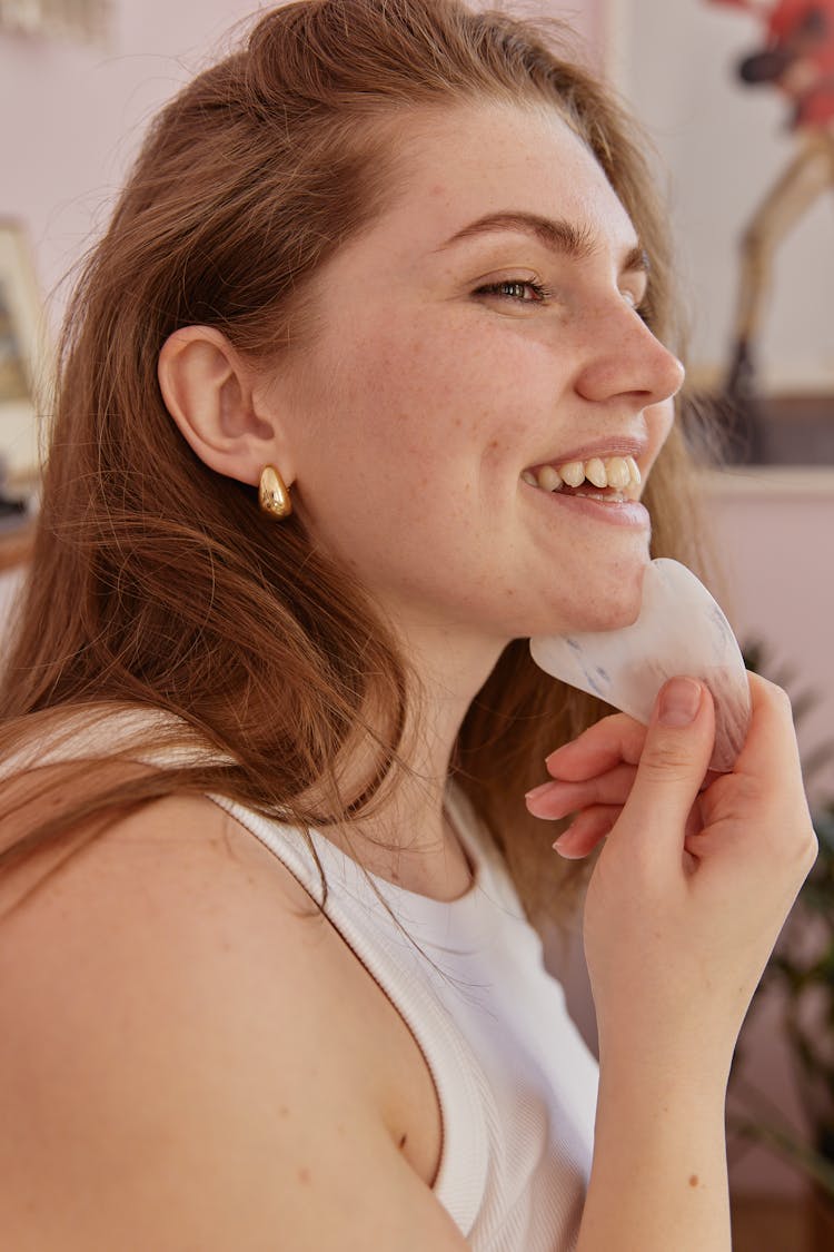 Woman Using A Gua Sha On Her Face 