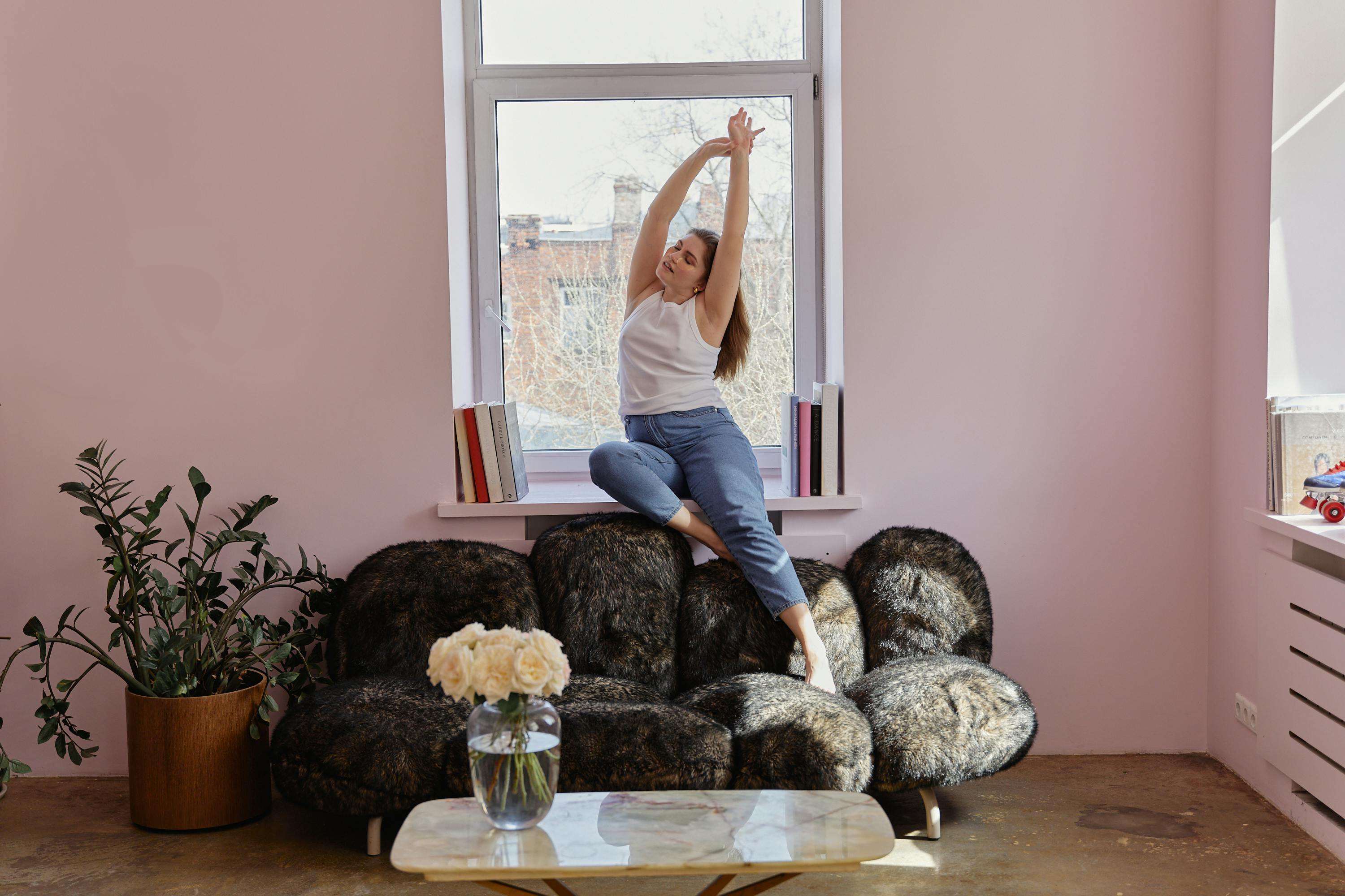 Aufgeräumte Fensterbank im Wohnzimmer mit Tablett, zwei Pflanzen und heller, ruhiger Farbwirkung