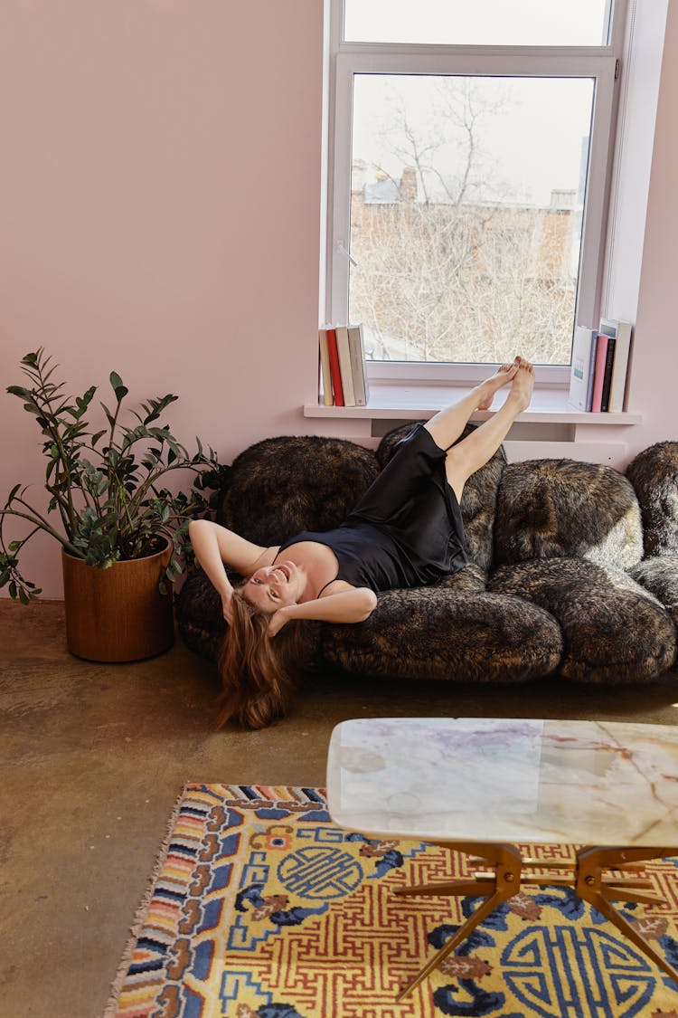 A Woman In Black Dress Lying On The Couch