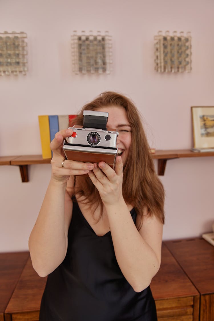 Laughing Woman Using A Vintage Polaroid Camera