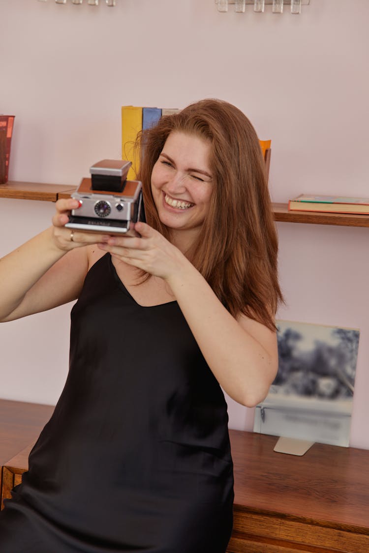 Woman Taking Photo Using A Polaroid SX-70 Camera