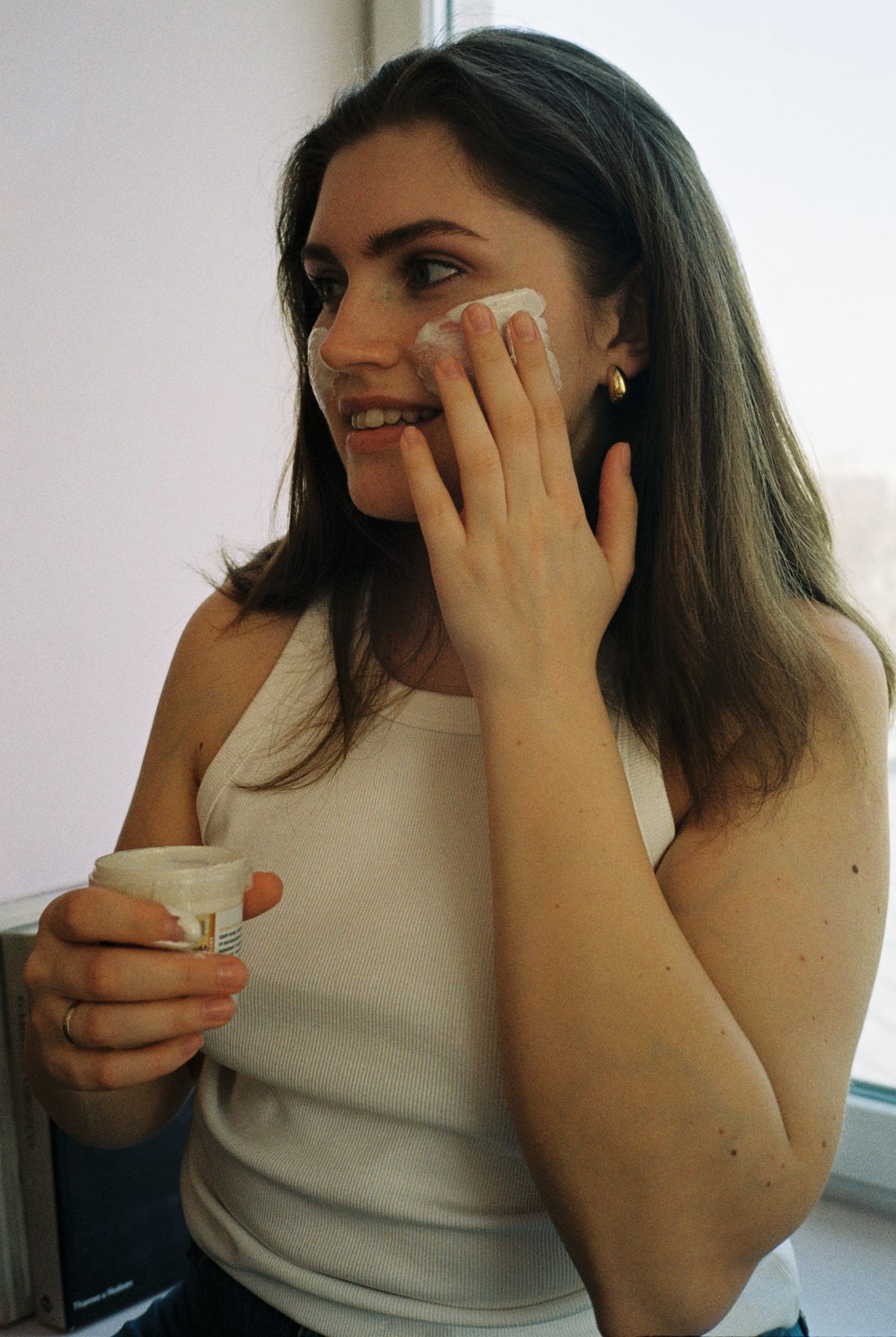 Mujer aplicando una crema facial en su rutina diaria