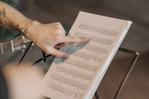 Person Pointing on Musical Notes